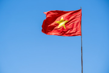 Red Vietnam flag against the blue sky