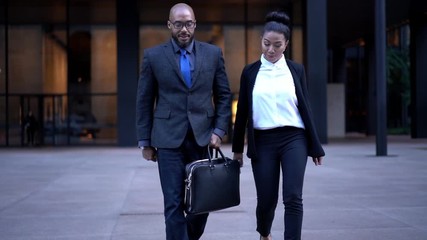 Owners of corporate companies getting to car gentleman opening automobile door for helping female colleague, slow motion effect of diverse lawyers in formal wear talking in financial district

