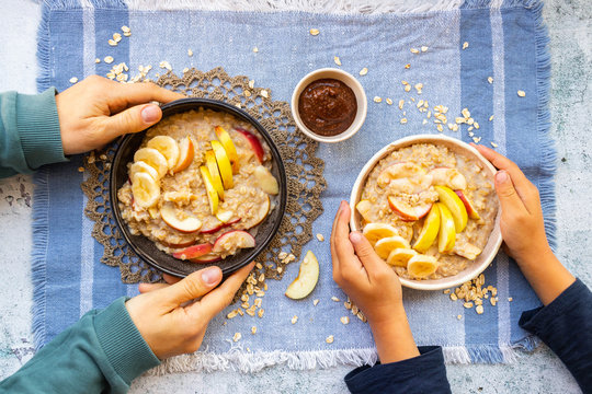 Oatmeal Porridge With Fruits. Apples And Bananas. Family Eat Vegan Food Breakfast Together. Overhead