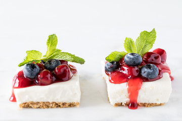 Front view of two cherry cheesecake squares garnished with mint.