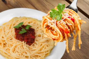 Metal fork with delicious spaghetti and sauce