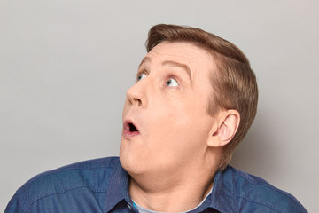 Fototapeta premium Portrait of shocked mature man with widened eyes and open mouth