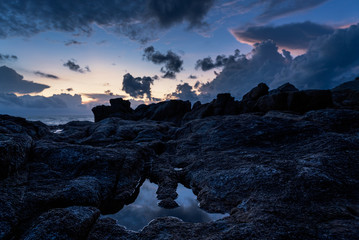 Dramatic sunrise over rocks and sea on a tropical island