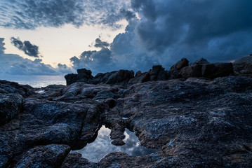 Dramatic sunrise over rocks and sea on a tropical island