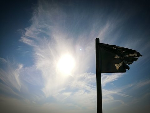 Low Angle View Of Pirate Flag Against Sky