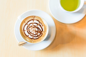 hot cappuccino coffee with green tea on table