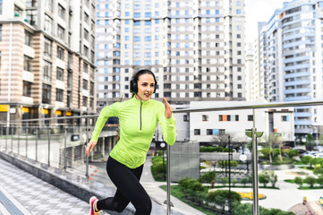 Best result. A young woman in a neon sports outfit runs a sprint on the street. Healthy lifestyle...