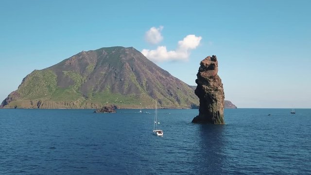 Aerial view on white sailing boats and yachts in Mediterranean sea against rocks and Lipari Islands. Horizon, blue sky. Sicily, Italy