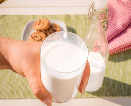 High Angle View Of Hand Holding Glass Of Milk
