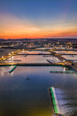 Obraz premium Aerial view of the prawn farm with aerator pump in front of Ninh Phuoc, Ninh Thuan, Vietnam. The growing aquaculture business continuously threatening the nearby wetlands.