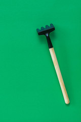 Rake for soil on a green background.