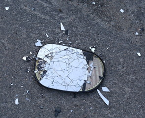 Broken car mirror lying on the asphalt