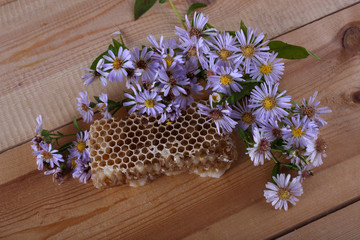 Honey and flowers on table
