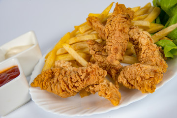 plate with french fries, crispy, fried meat, vegetables, juices and bread