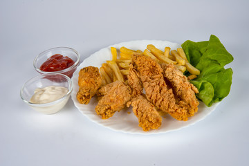 plate with french fries, crispy, fried meat, vegetables, juices and bread