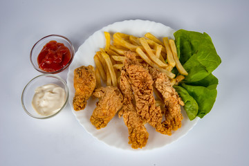 plate with french fries, crispy, fried meat, vegetables, juices and bread
