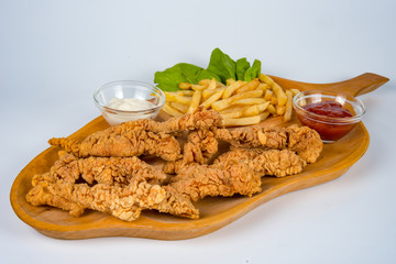 plate with french fries, crispy, fried meat, vegetables, juices and bread