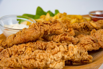 plate with french fries, crispy, fried meat, vegetables, juices and bread