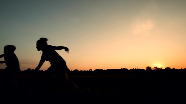 Silhouette of mother and son riding bicycles at sunset