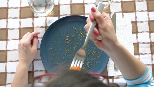 Woman eating fresh pasta with fork, from above