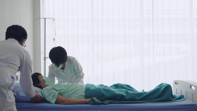 Asian doctor and nurse doing cpr to the patient who has sudden cardiac arrest from heart attack in hospital. healthcare and medical concept