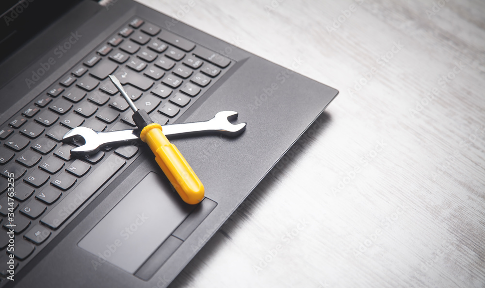 Wall mural Wrench and screwdriver on the computer keyboard. IT Service. Support