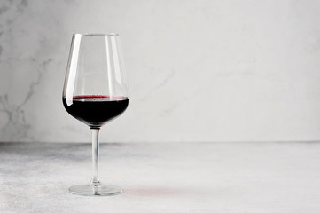 long-stemmed glass with red wine on a grey background