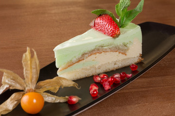 Piece of green tea crape cake on black plate