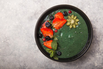 Colorful, healthy food. Acai smoothie bowl. Keto breakfast idea. Fruit curd smoothie, acai. Breakfast with green spirulina, strawberry, chia, kiwi in black plate
