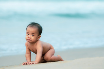 Fototapeta na wymiar portrait of asain infant crawling on beautiful sea beach