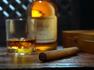 NO LOGOS OR TRADEMARKS!  SELF MADE LABELS! close up view of cigar, bottle of whiskey and a glass aside on color back. 