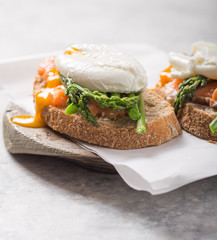 Healthy vegetarian meal. Toast,  poached egg, asparagus, salmon fish. Stone background. Clean eating Diet. Organic food.