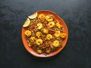 Stir fry noodles with fried shrimps, vegetables and soy sauce. Asian food background