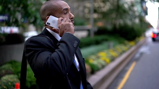 Slow motion effect of Latin businessman contacting operator service for making international consultancy during way time in downtown, concept of roaming connection on modern cellphone
