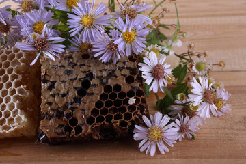 Honey and flowers on table