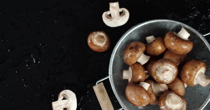 Mushrooms in a colander falling water drops.