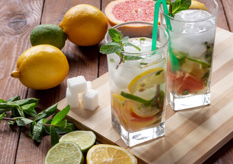 Summer refreshing drink with ice. Three types of citrus lime, lemon, pink grapefruit. Natural citrus lemonade with mint.