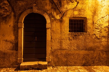 Porta e finestra sbarrata. Borgo medioevale di Strassoldo, fotografia notturna.