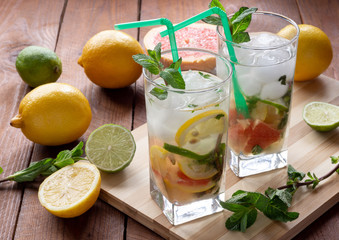 Summer refreshing drink with ice. Three types of citrus lime, lemon, pink grapefruit. Natural citrus lemonade with mint.