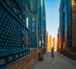 Woman tourist stands near the ancient building in the city of Samarkand in Uzbekistan
