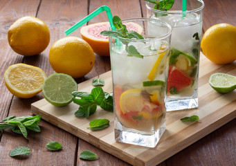 Summer refreshing drink with ice. Three types of citrus lime, lemon, pink grapefruit. Natural citrus lemonade with mint.