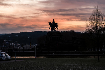 Fototapeta premium Colorful Sunrise burning sky Koblenz City historic monument German Corner where river rhine and mosele flow together