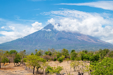 Mt. Agung covered with clouds in front of the blue sky in Bali