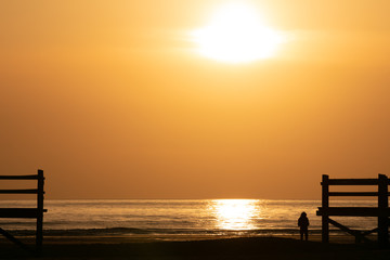 Silhouette of a woman by the sea at sunset