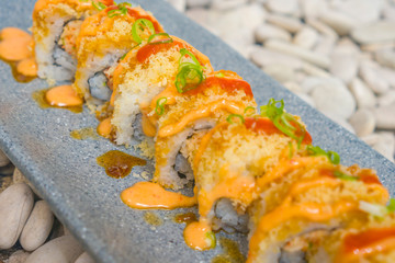 Japan gourmet cuisine - closeup detail on delicious and delicate dish of Japanese sushi rolls in slate on stone bg in traditional healthy Asian food and creative oriental dining