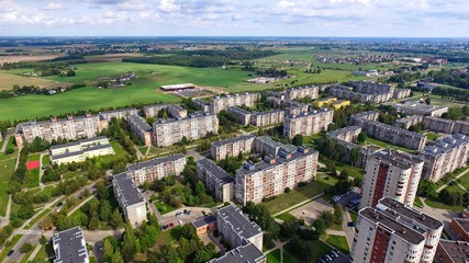 Aerial panoramic view of the southern part of Siauliai city in Lithuania.Old soviet union buildings with green naturearound and yards full of cars in a sunny day.