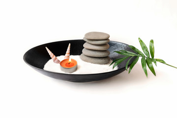 Spa still life with stones and burning candles in a Cup palm leaf on a white background. The concept of Eastern traditions, beauty and health.