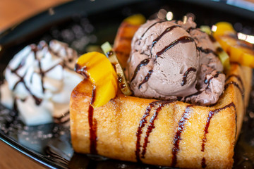 Toasted bread and chocolate ice cream with fruits topping. Chocolate  Ice cream with toasted bread on plate. Ice cream with toasted and chocolate topping in Coffee shop.