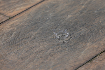 raindrop splashing into a puddle on slate floor