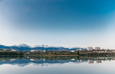Fototapeta na wymiar Kazakhstan nature lake reflection in water trees and mountains